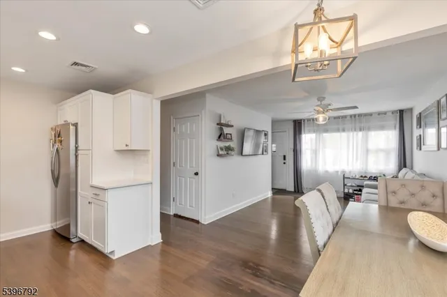 a living room with stainless steel appliances furniture and kitchen view