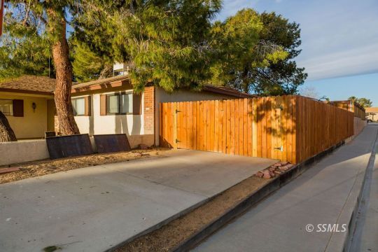 543 South Warner Street Ridgecrest, CA 93555 - Photo 5 of 27 a view of backyard with large tree and wooden fence