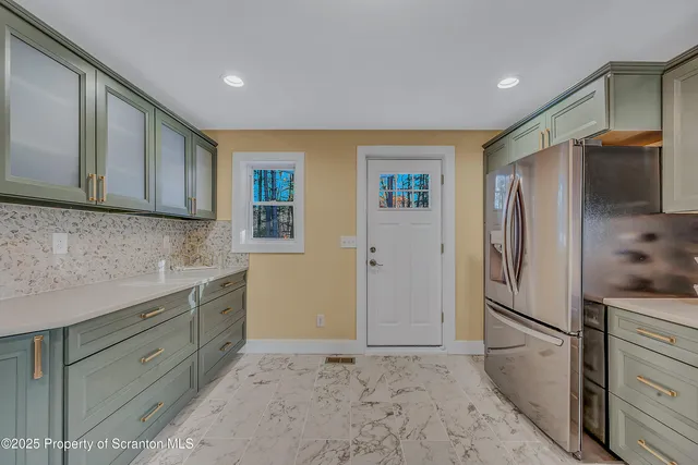 a kitchen with stainless steel appliances granite countertop a refrigerator and a sink