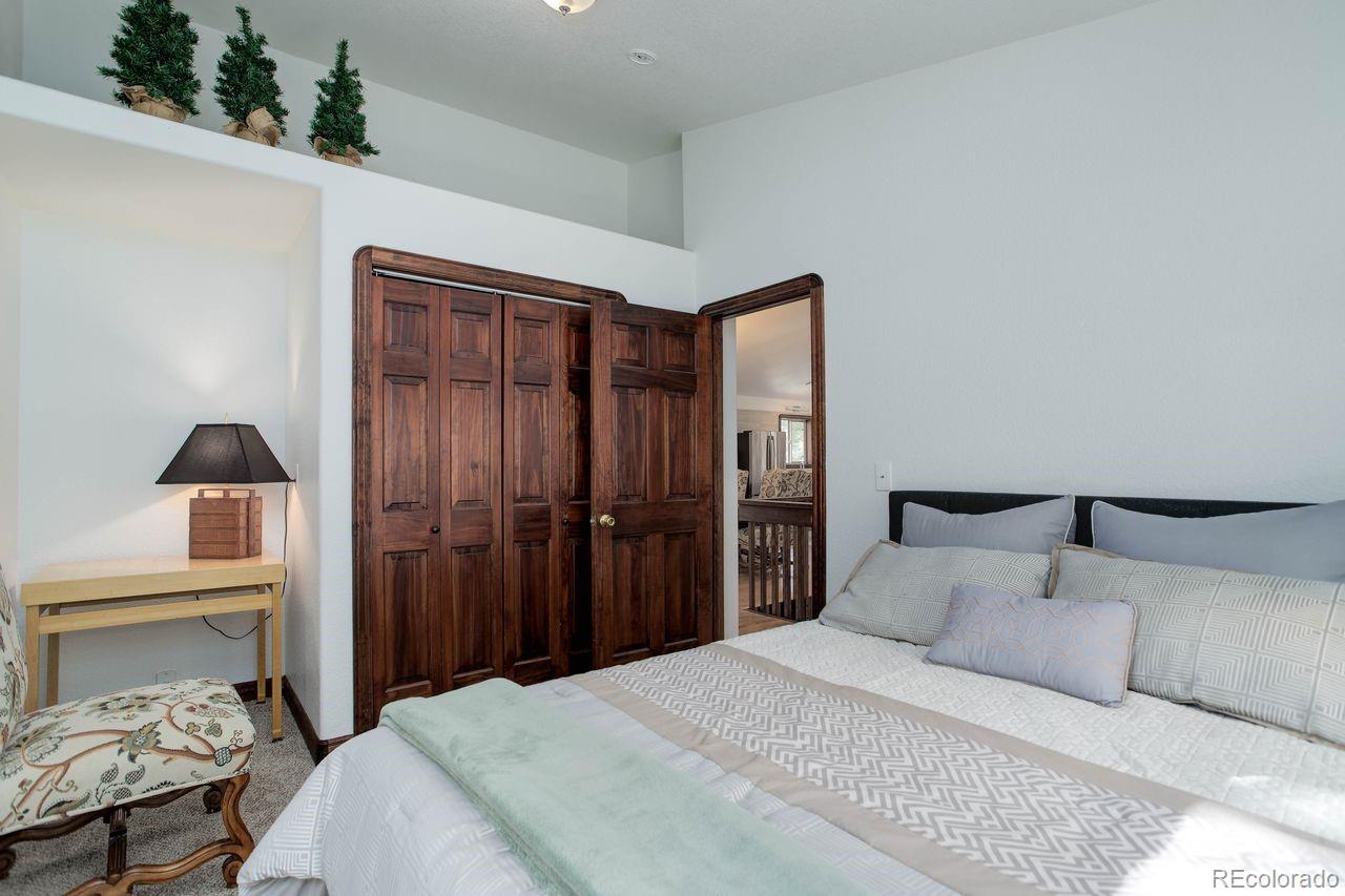 264 North Fork Road Grant, CO 80448 - Photo 20 of 34 a bedroom with a bed and a lamp