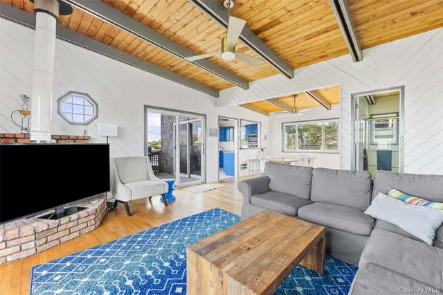 a living room with furniture a flat screen tv and a floor to ceiling window