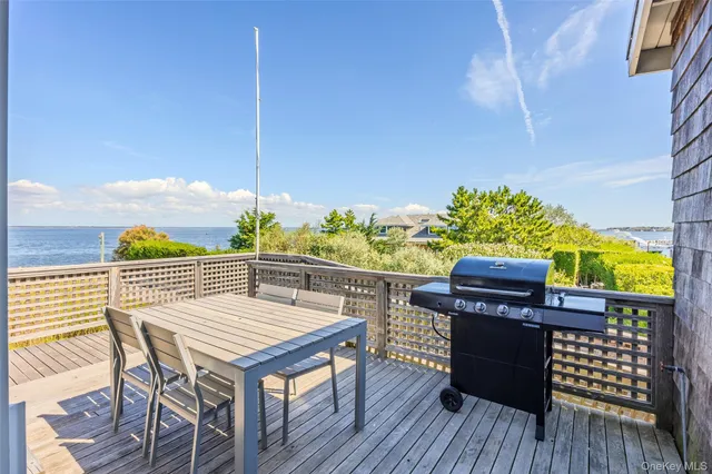 a view of a roof deck with table and chairs with wooden floor