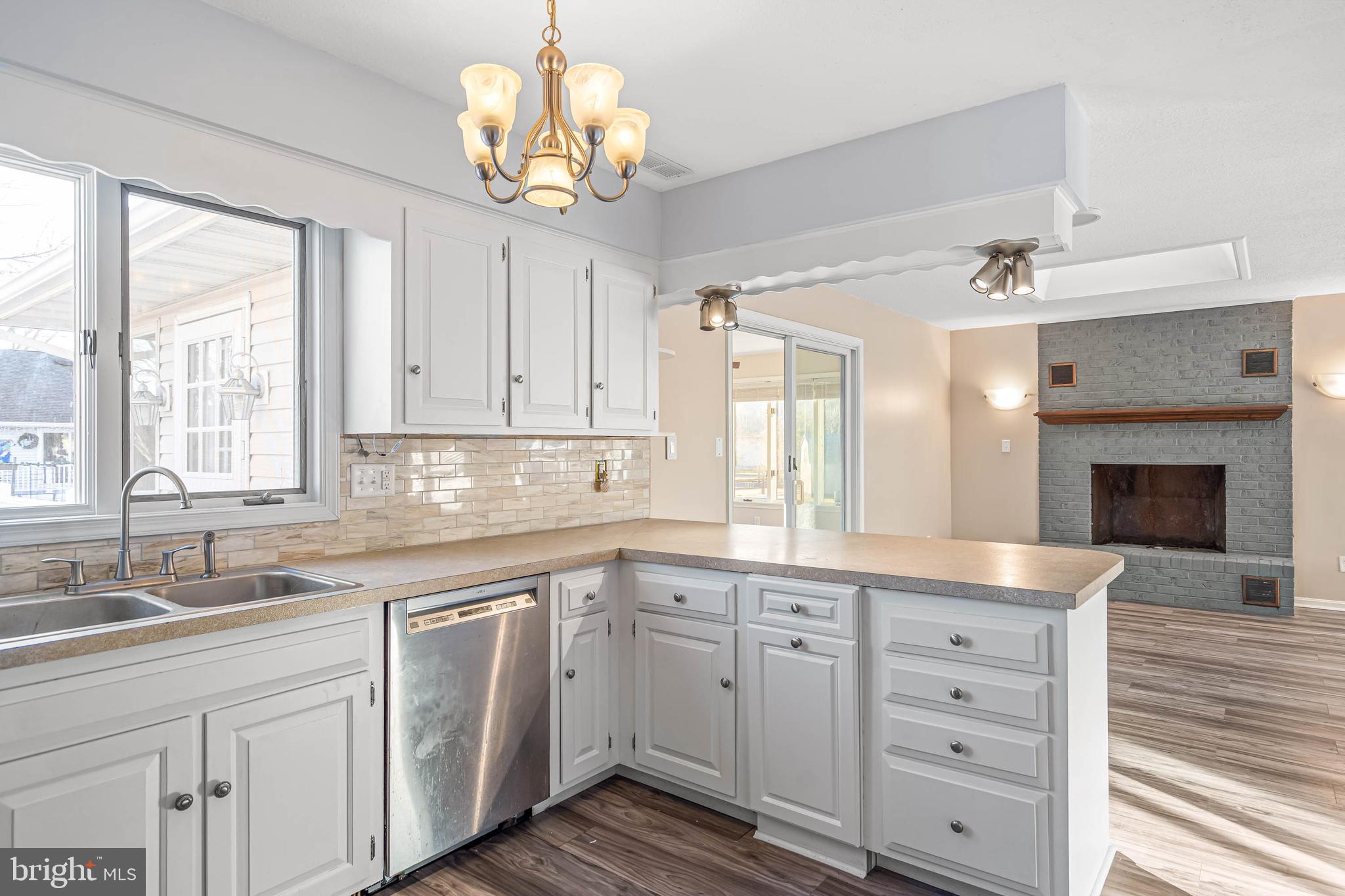 521 Harbor Road Ocean View, DE 19970 - Photo 19 of 32 a kitchen with white cabinets and chandelier