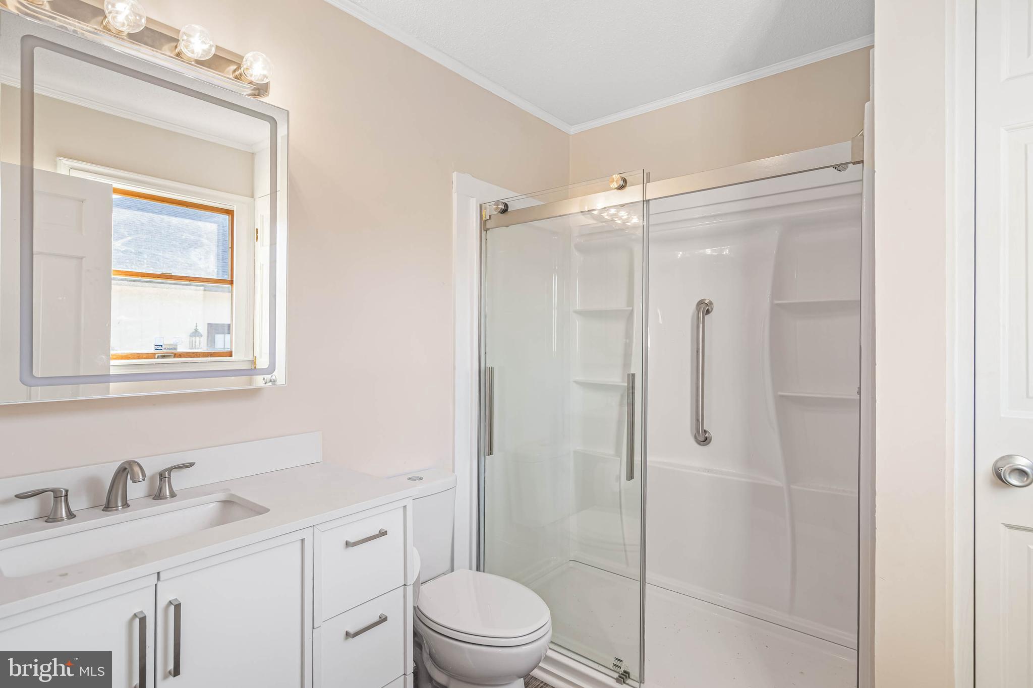 521 Harbor Road Ocean View, DE 19970 - Photo 24 of 32 a bathroom with a granite countertop sink toilet a mirror and shower