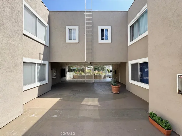 a view of a big room with wooden floor and a kitchen