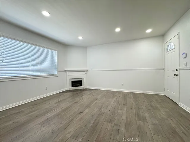 wooden floor in an empty room with a kitchen