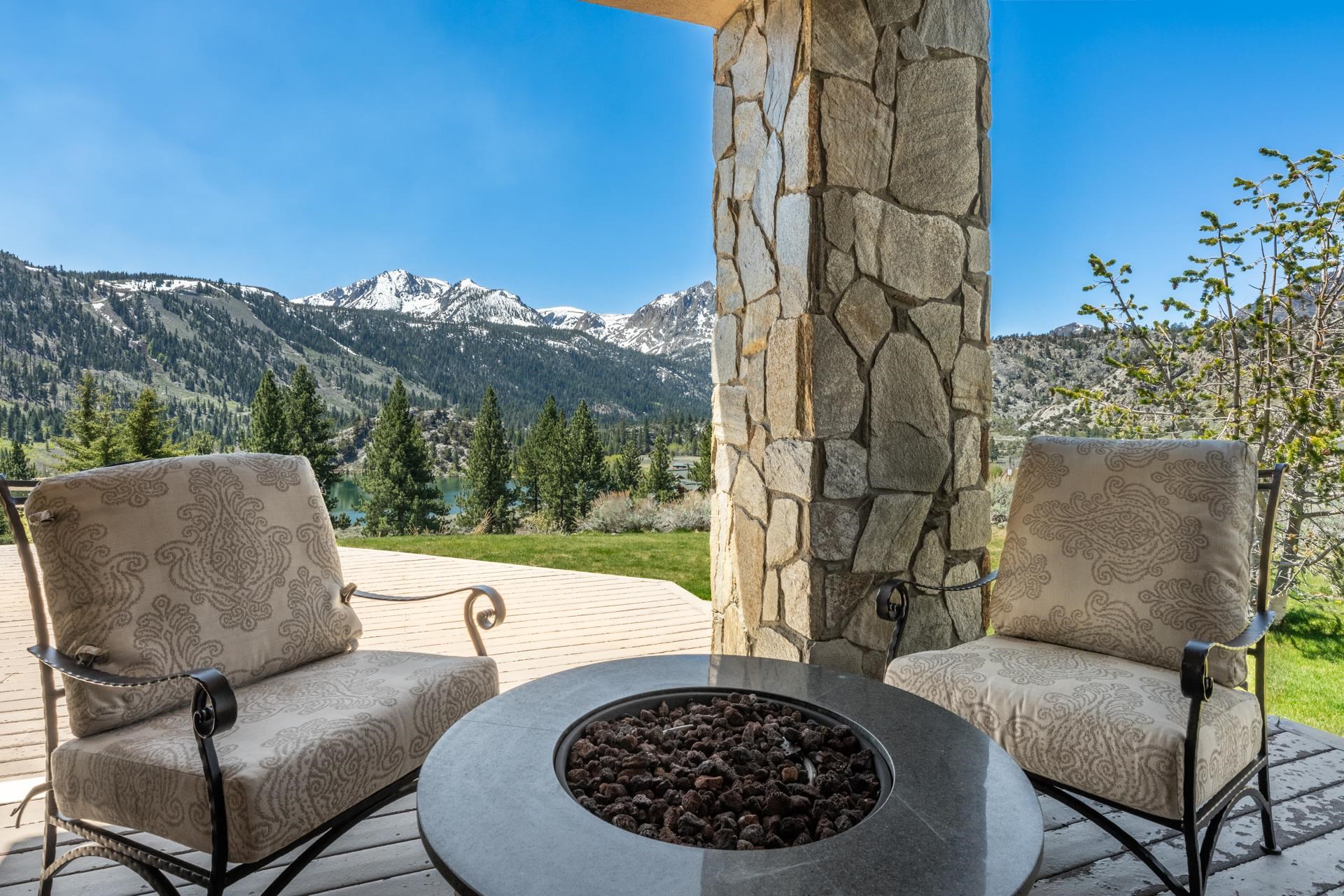 45 Skyline Road June Lake, CA 93529 - Photo 23 of 58 Expansive outdoor patio with a stone pillar, overlooking a serene lake and snow-capped mountains