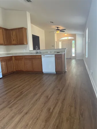 a kitchen with stainless steel appliances wooden floors wooden cabinets and entryway