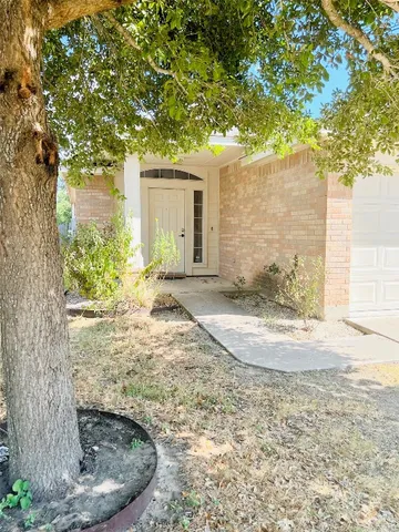 a view of a house with a tree in the yard
