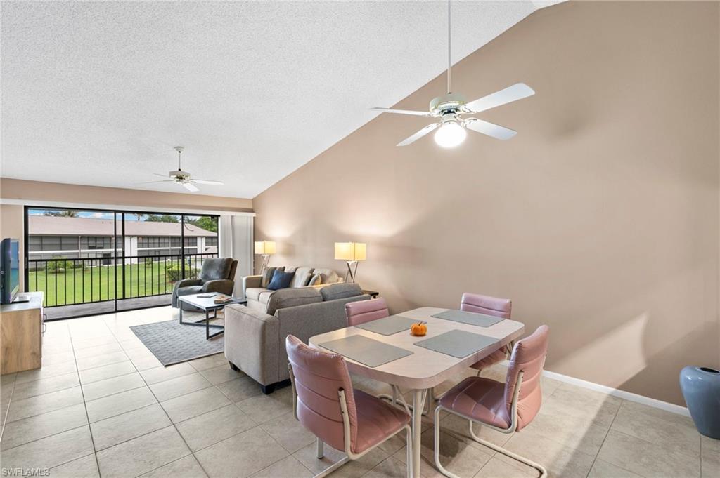 236 Pebble Beach Circle, Unit A202 Naples, FL 34113 - Photo 2 of 25 a living room with furniture a ceiling fan and a floor to ceiling window