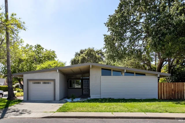 a front view of a house with a garden