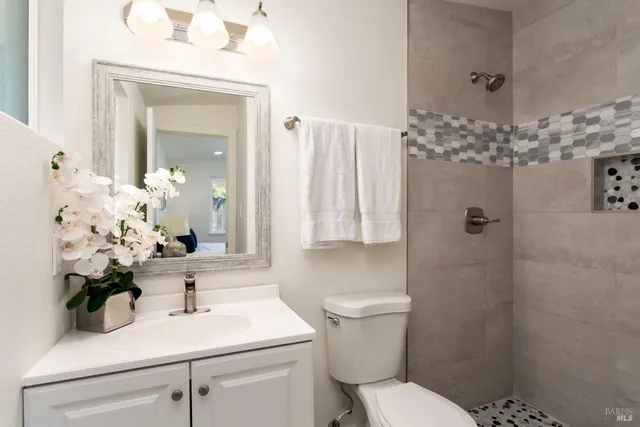 a bathroom with a sink a toilet and a mirror