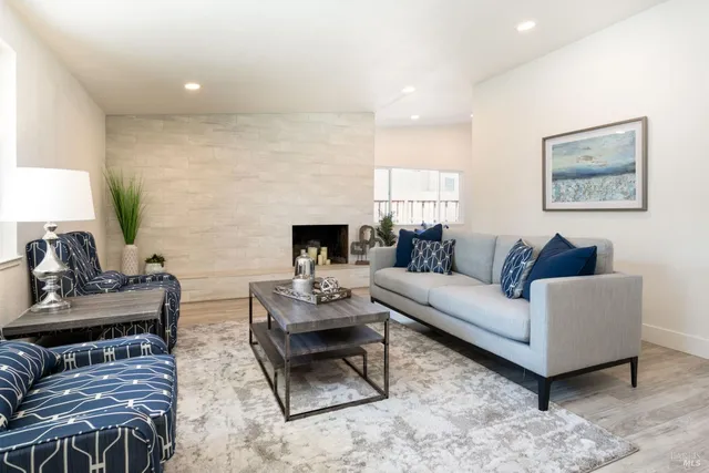a living room with furniture a fireplace and a flat screen tv