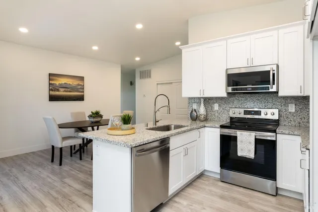 a kitchen with stainless steel appliances kitchen island granite countertop a sink and cabinets
