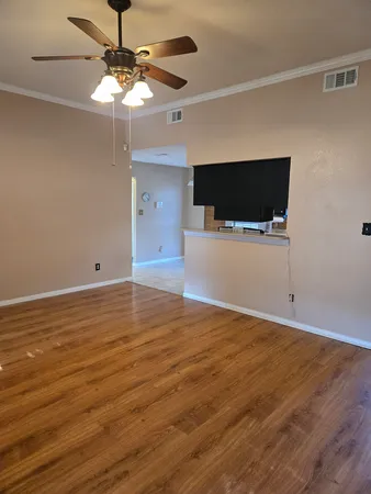 a view of a livingroom with an empty space and a ceiling fan