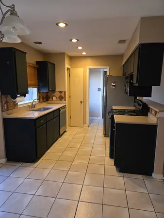 a kitchen with stainless steel appliances granite countertop a sink and a stove