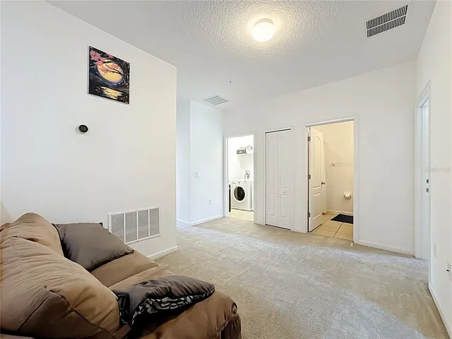 a living room with furniture and a baby crib