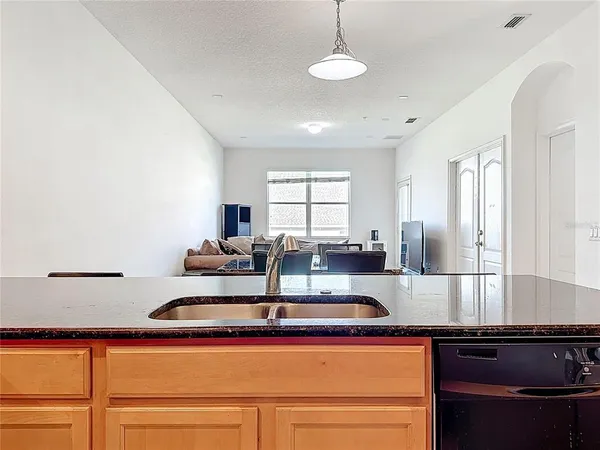 a kitchen with stainless steel appliances granite countertop a sink and a refrigerator
