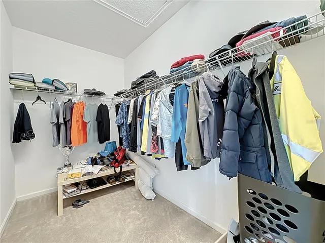 a view of walk in closet with clothes and shoes