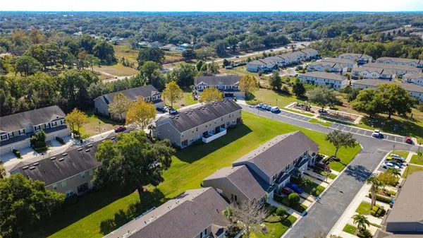 an aerial view of a swimming pool yard and mountain view in back