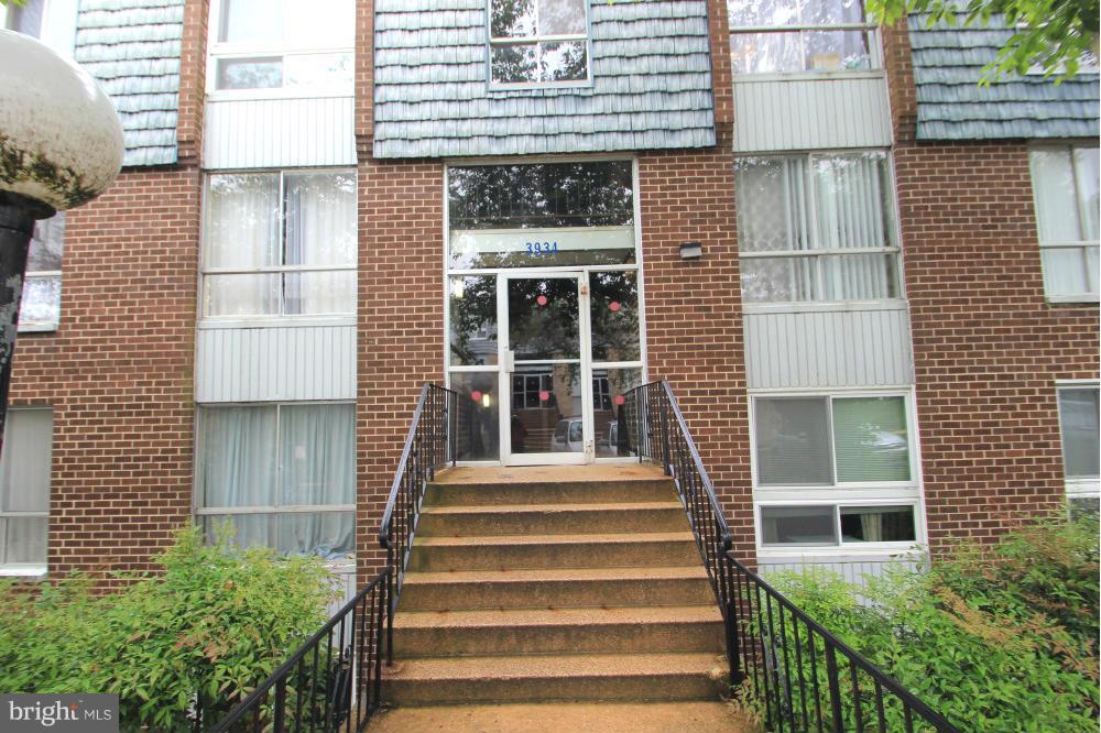 3934 Bel Pre Road, Unit 1 Silver Spring, MD 20906 - Photo 1 of 12 a view of a brick house with large windows and potted plants