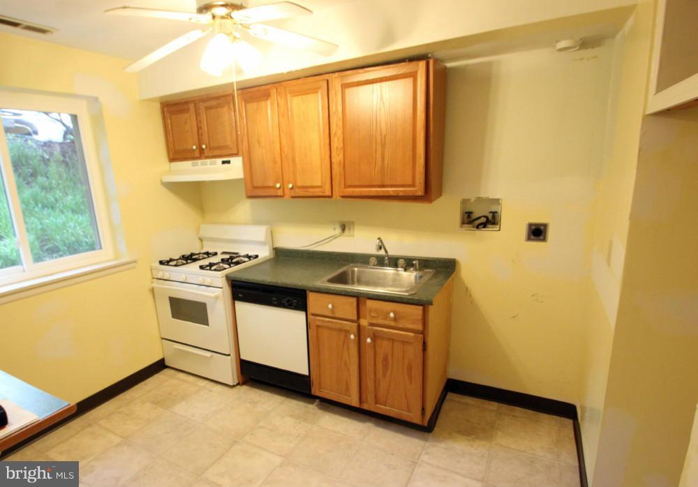 3934 Bel Pre Road, Unit 1 Silver Spring, MD 20906 - Photo 5 of 12 a kitchen with a sink a stove and cabinets