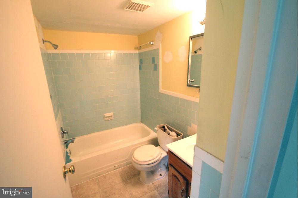 3934 Bel Pre Road, Unit 1 Silver Spring, MD 20906 - Photo 10 of 12 a white toilet sitting next to a bathroom sink and vanity