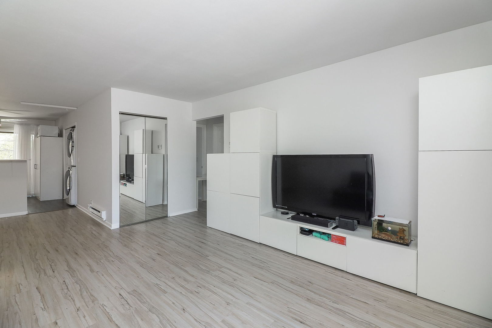 201 North Waters Edge Drive, Unit 302 Glendale Heights, IL 60139 - Photo 3 of 18 a view of a livingroom with wooden floor and a flat screen tv
