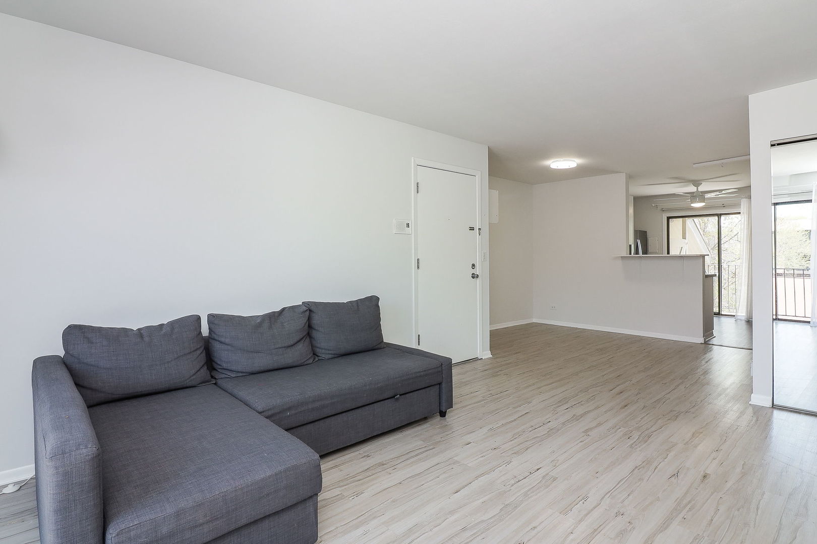 201 North Waters Edge Drive, Unit 302 Glendale Heights, IL 60139 - Photo 4 of 18 a living room with furniture and a wooden floor