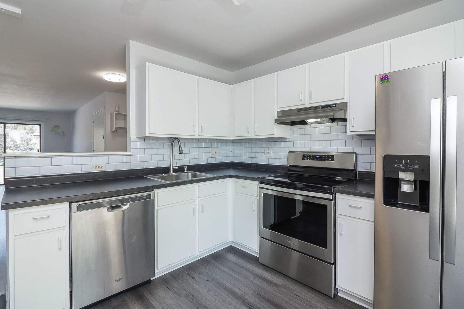 201 North Waters Edge Drive, Unit 302 Glendale Heights, IL 60139 - Photo 6 of 18 a kitchen with stainless steel appliances white cabinets and a sink