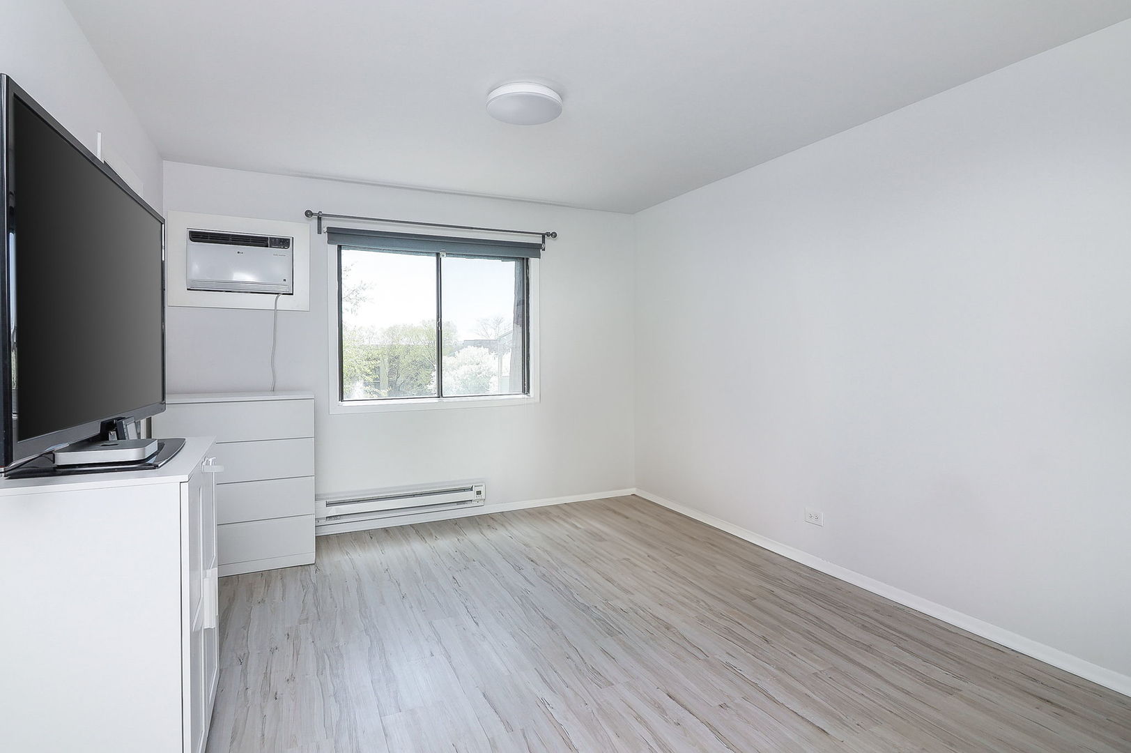 201 North Waters Edge Drive, Unit 302 Glendale Heights, IL 60139 - Photo 9 of 18 wooden floor in an empty room with a window