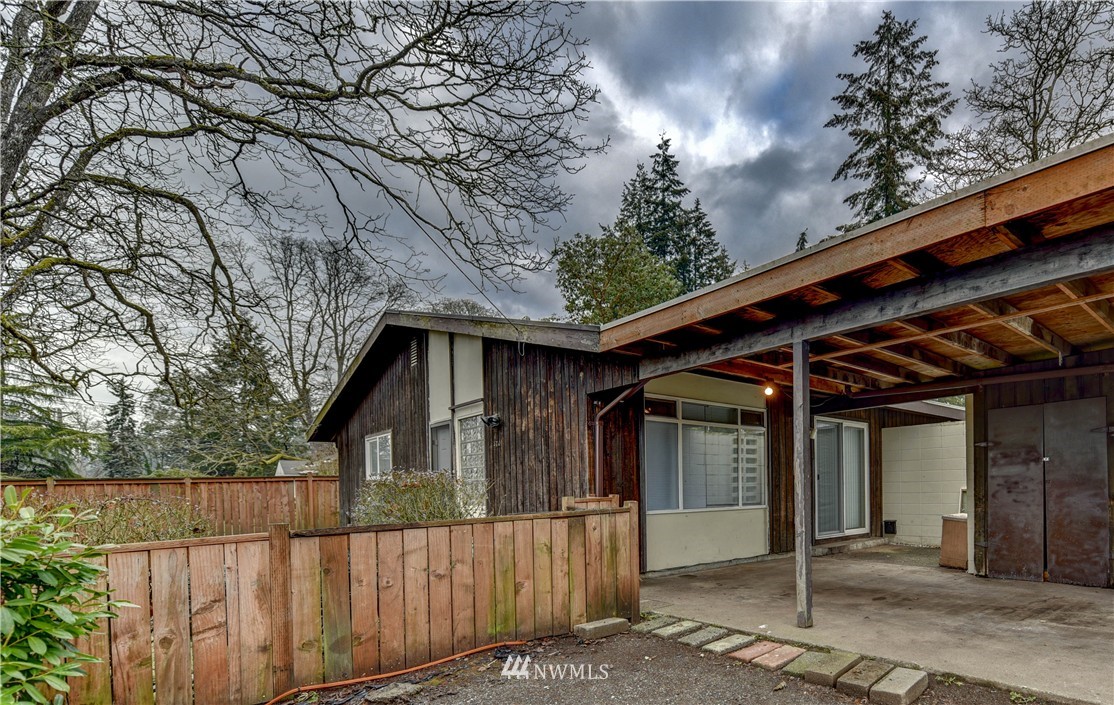 8701-8703 Custer Road Southwest Lakewood, WA 98499 - Photo 2 of 17 a view of a house with a large tree and wooden fence