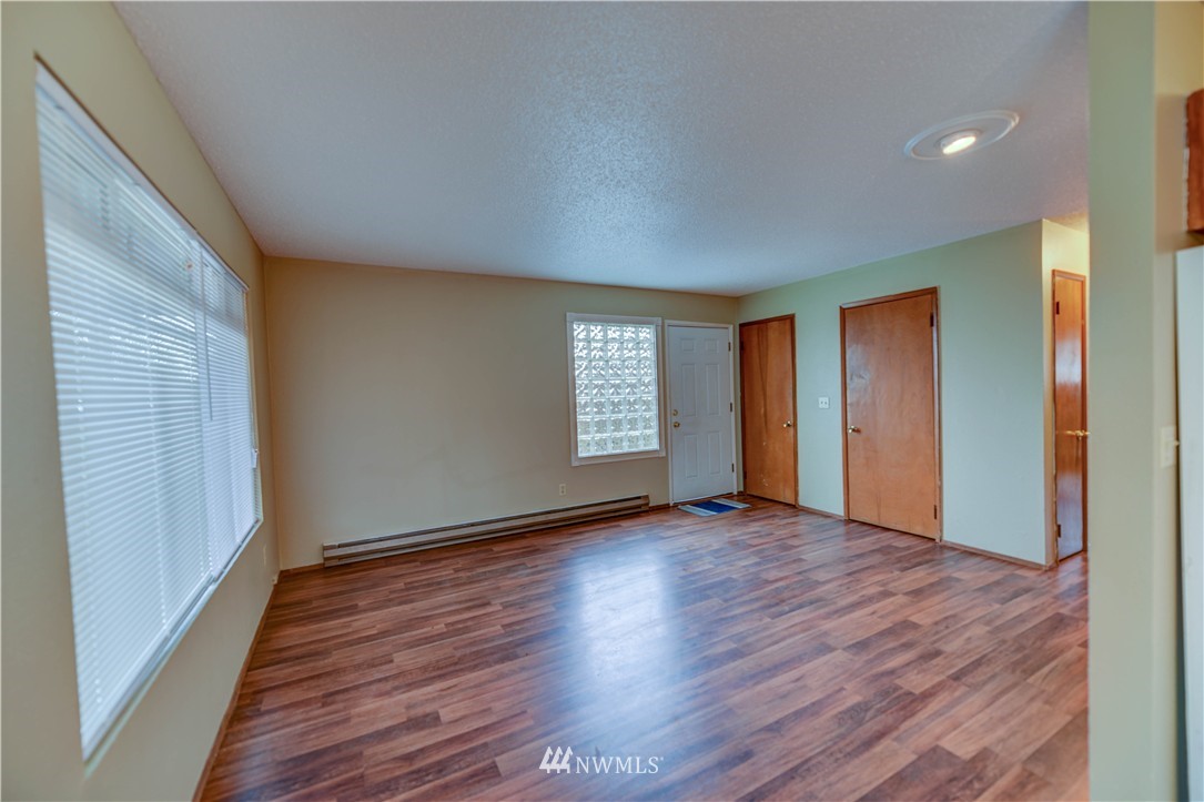 8701-8703 Custer Road Southwest Lakewood, WA 98499 - Photo 11 of 17 a view of an empty room with wooden floor and a window