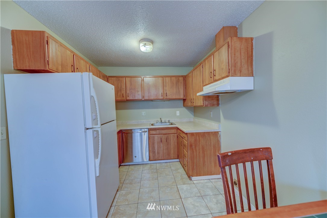 8701-8703 Custer Road Southwest Lakewood, WA 98499 - Photo 13 of 17 a kitchen with stainless steel appliances granite countertop a refrigerator sink and cabinets