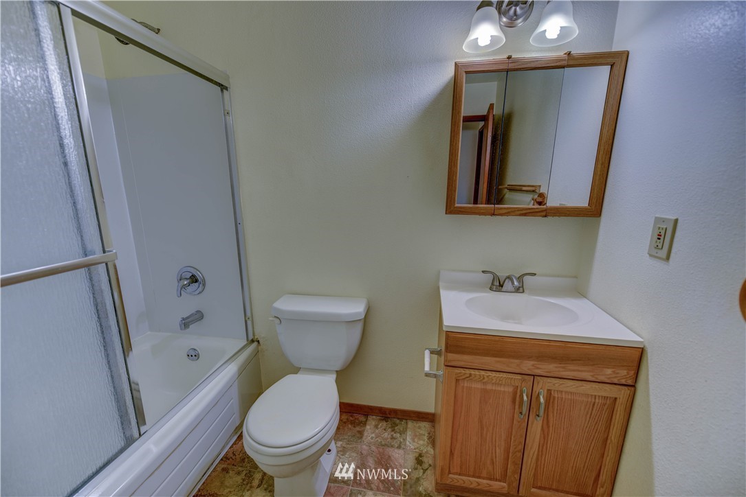 8701-8703 Custer Road Southwest Lakewood, WA 98499 - Photo 7 of 17 a bathroom with a toilet sink and mirror