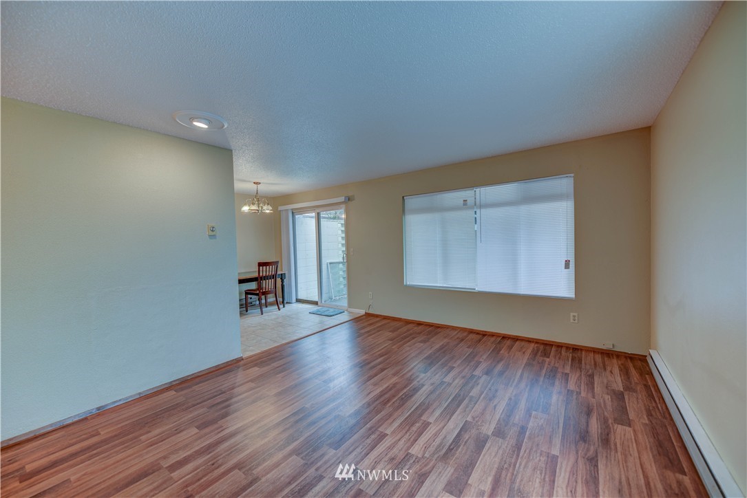 8701-8703 Custer Road Southwest Lakewood, WA 98499 - Photo 10 of 17 a view of an empty room with wooden floor and a window