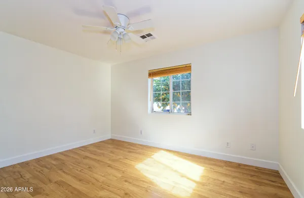 an empty room with a window and a ceiling fan