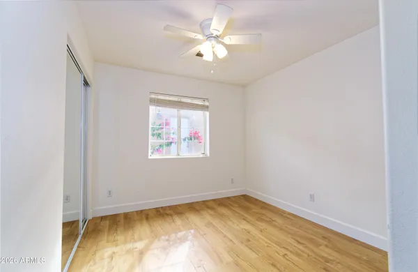 an empty room with a window and a ceiling fan