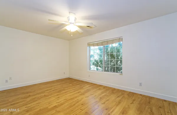 an empty room with a window and a fan