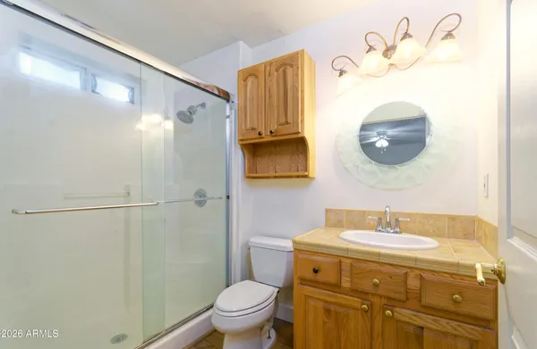 a bathroom with a sink a toilet and a mirror