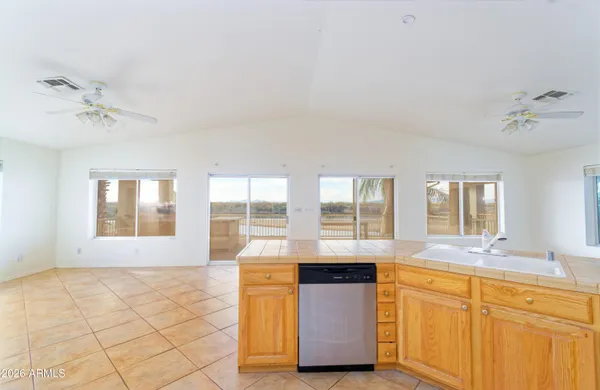 a view of kitchen with granite countertop a sink a stove cabinets and dining area