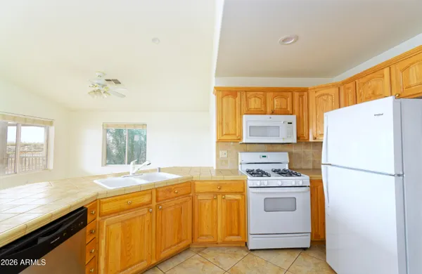 a kitchen with white cabinets and white appliances