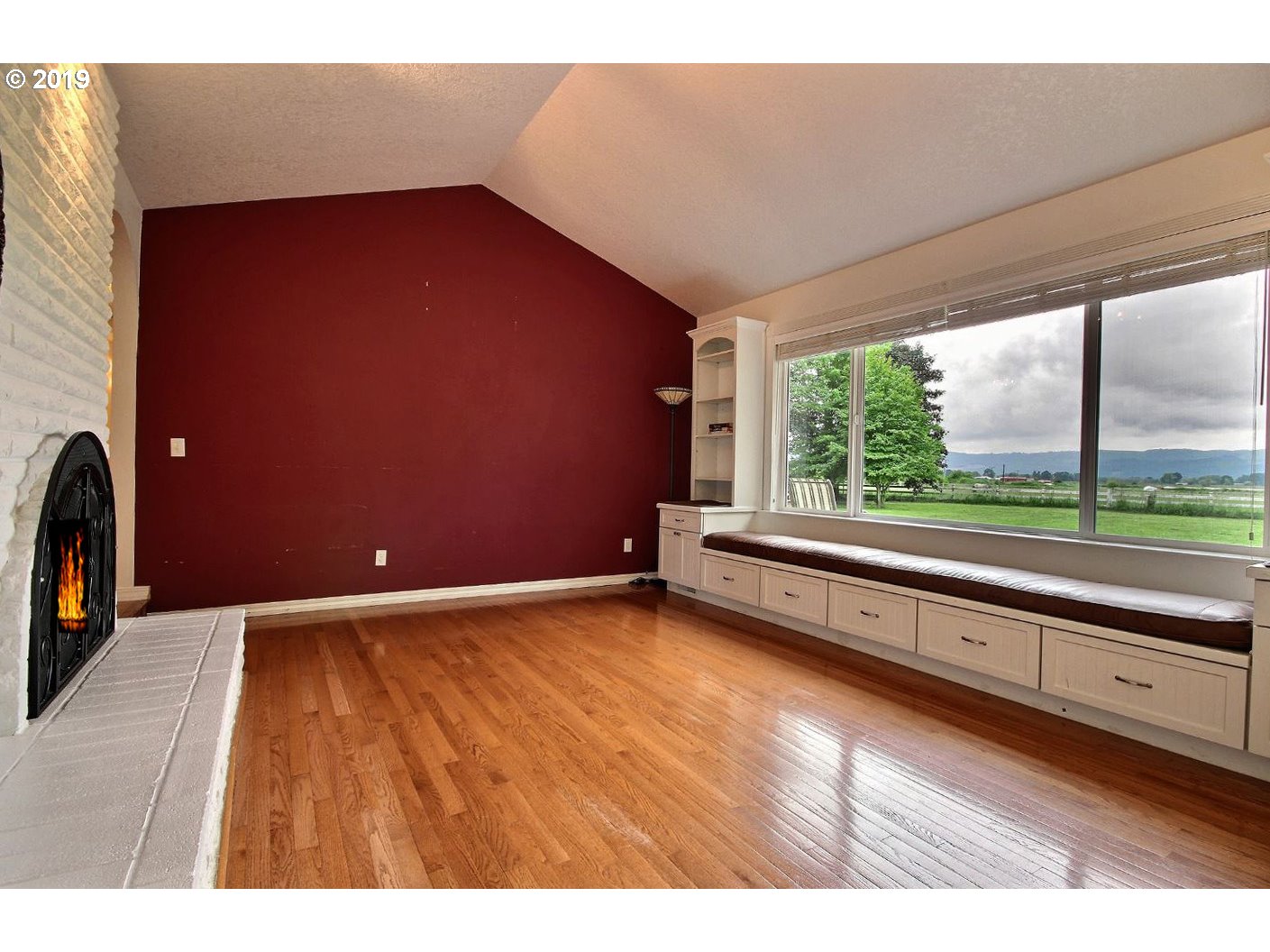 22505 Northwest Gillihan Road Portland, OR 97231 - Photo 9 of 32 a view of an empty room with wooden floor and a fireplace