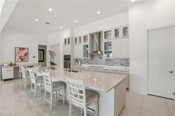a kitchen with stainless steel appliances granite countertop a table and chairs