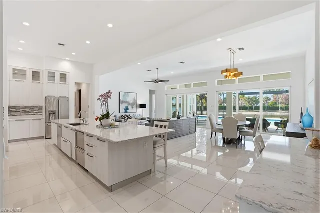 a large white kitchen with a large window and counter top
