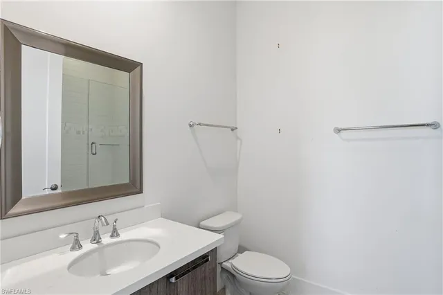 a bathroom with a sink toilet vanity and shower