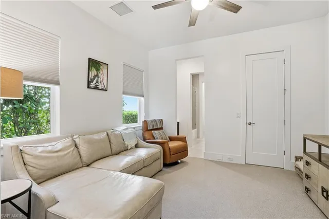 a living room with furniture a ceiling fan and a window