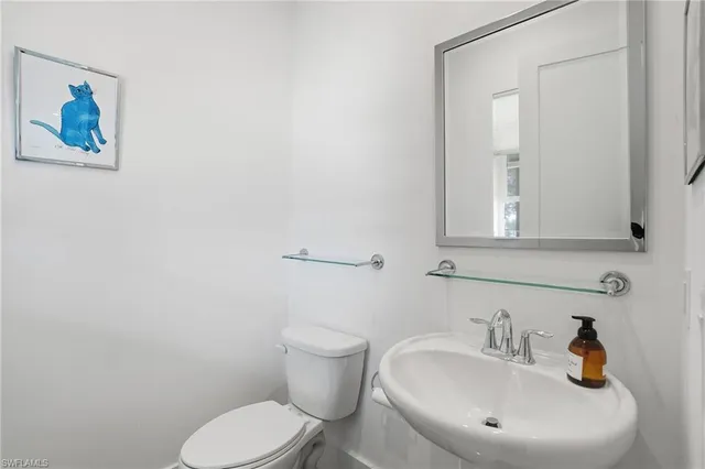 a bathroom with a toilet sink and mirror