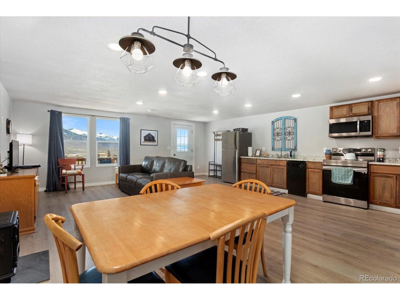 51624 Co Road Villa Grove, CO 81155 - Photo 40 of 50 a living room with stainless steel appliances kitchen island granite countertop a table chairs and a refrigerator