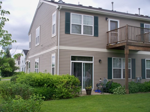 3016 Falling Waters Lane, Unit 3016 Lindenhurst, IL 60046 - Photo 19 of 21 a front view of a house with a garden and plants